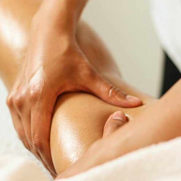 Close-up of a therapist performing a soothing leg massage, enhancing relaxation and wellness.